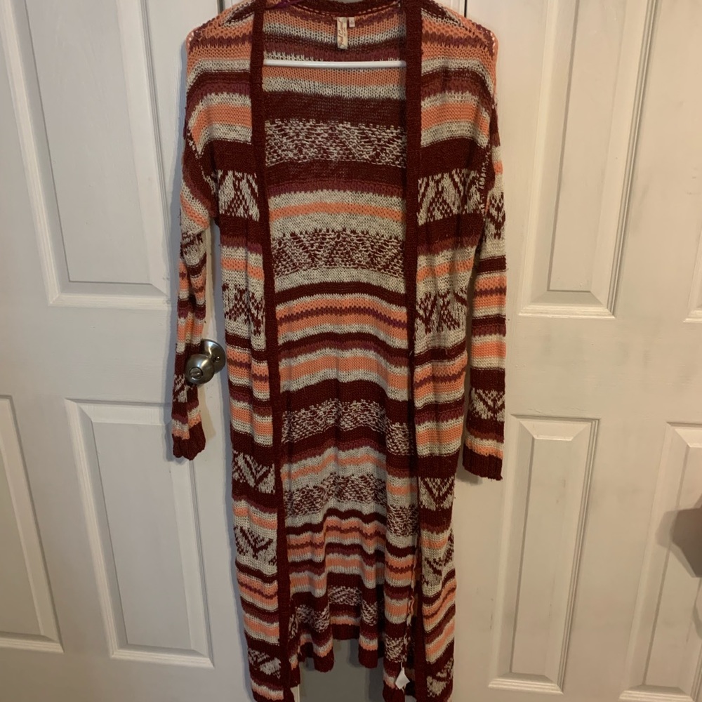 long stripped white, coral, and maroon sweater.